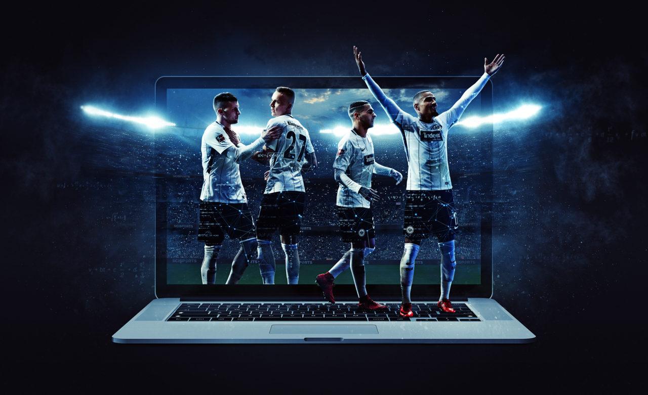 Visualisation of celebrating Eintracht Frankfurt players in front of a laptop and a stadium in the background