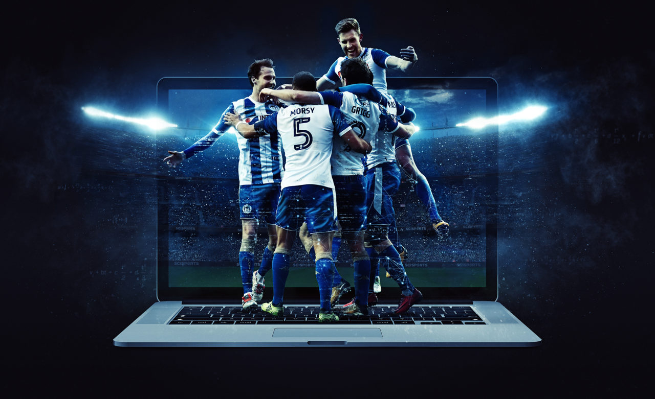 Visualisation of Wigan Athletic players celebrating in front of a laptop and with a stadium at night in the background