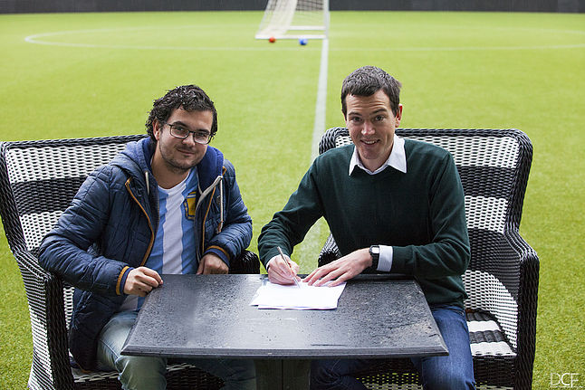 Image of Bram Ton's contract signing with a football field on the background