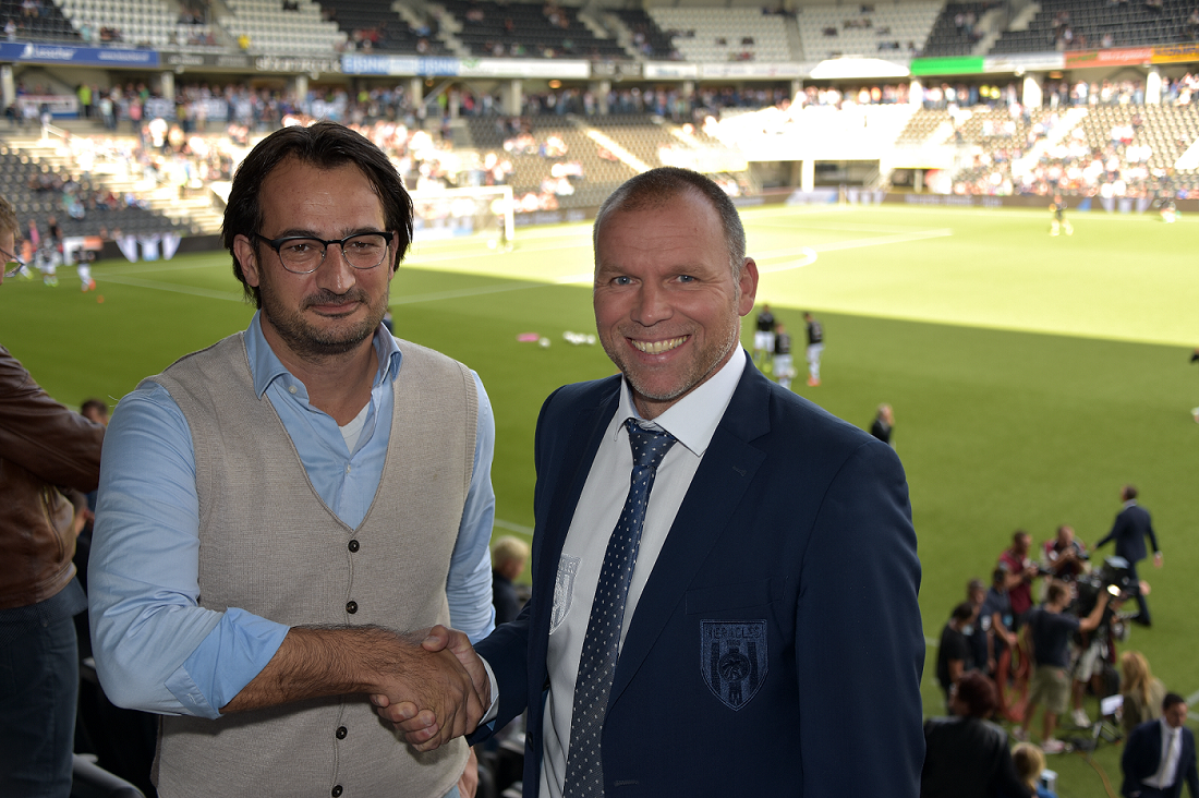 Image of Hand d'Hollosy and Nico-Jan Hoogma shaking hands in Heracles stadium after contract signing