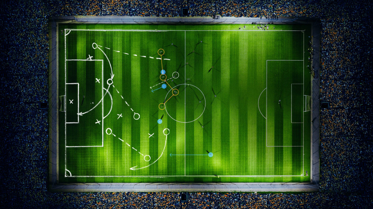 Visualisation of a football stadium at night from above with tactical instructions on the field